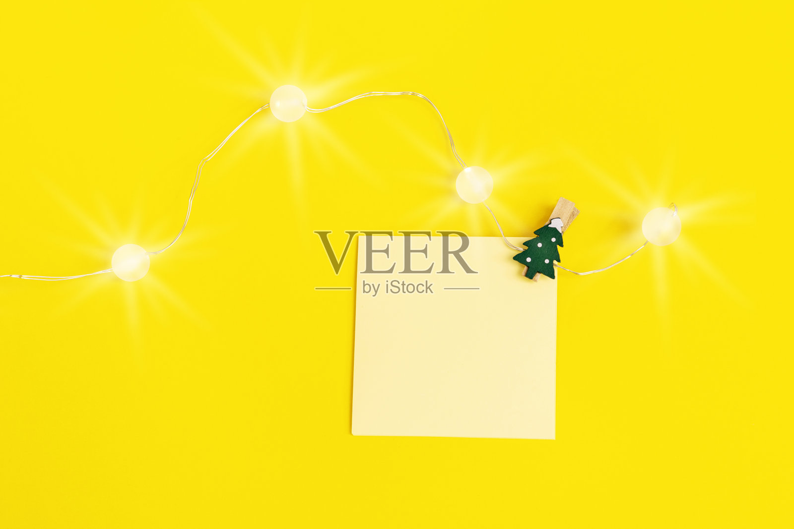 给朋友和同事写圣诞祝福的空白纸条。方形便笺提醒黄色和新年装饰。照片摄影图片