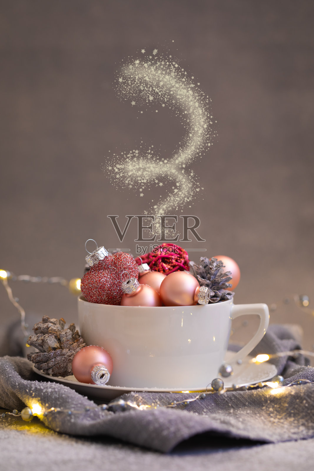 粉红色的圣诞球和天然锥形在白茶设置在灰色的背景,调照片摄影图片