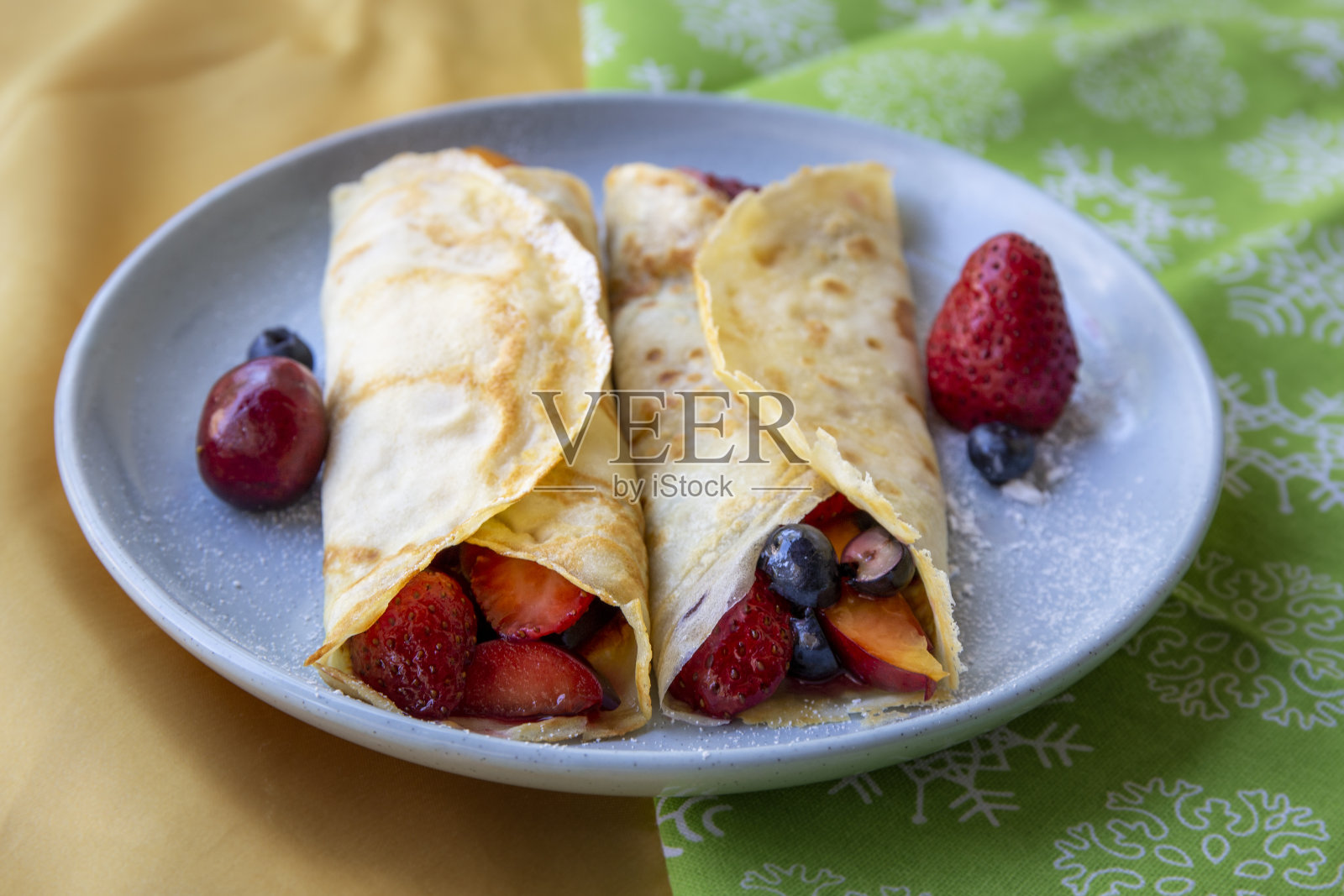 可丽饼配新鲜浆果,巧克力酱和糖粉照片摄影图片