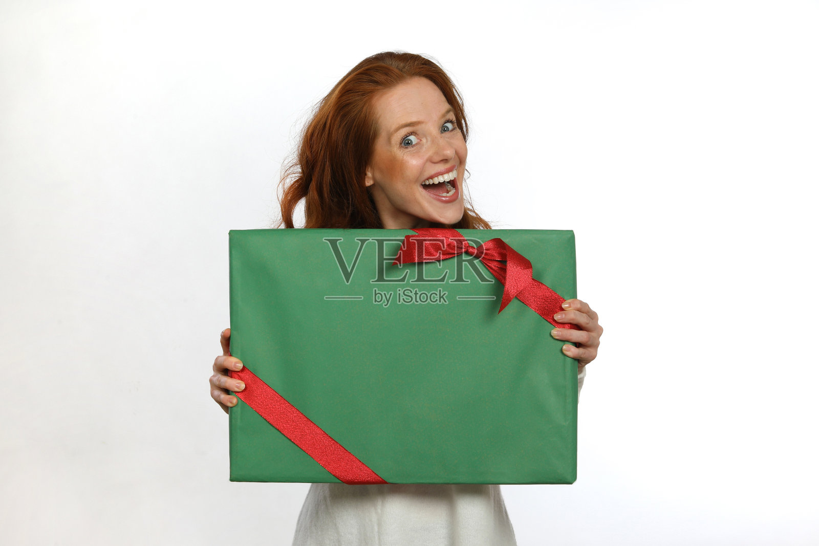 一位红发美女拿着一份绿色包装的礼物照片摄影图片