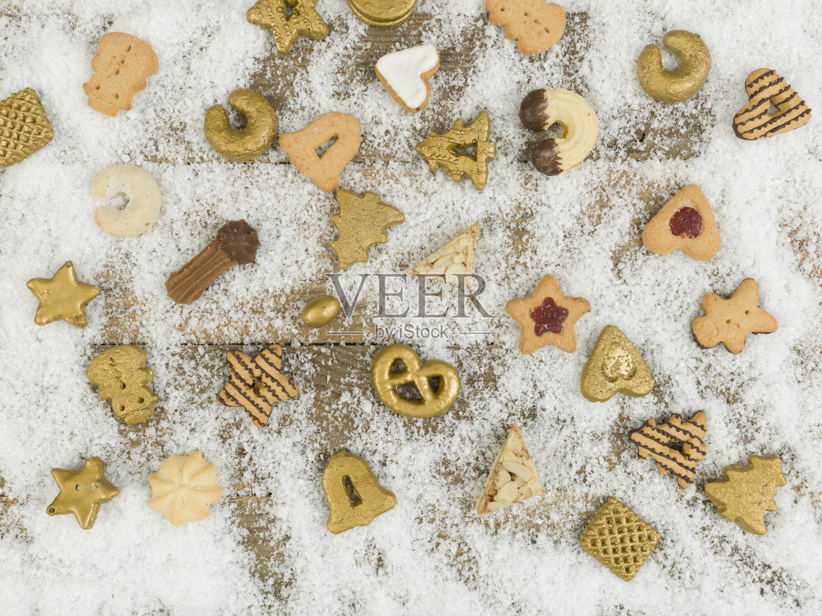 不同的圣诞饼干在白色的雪和木制的背景照片摄影图片