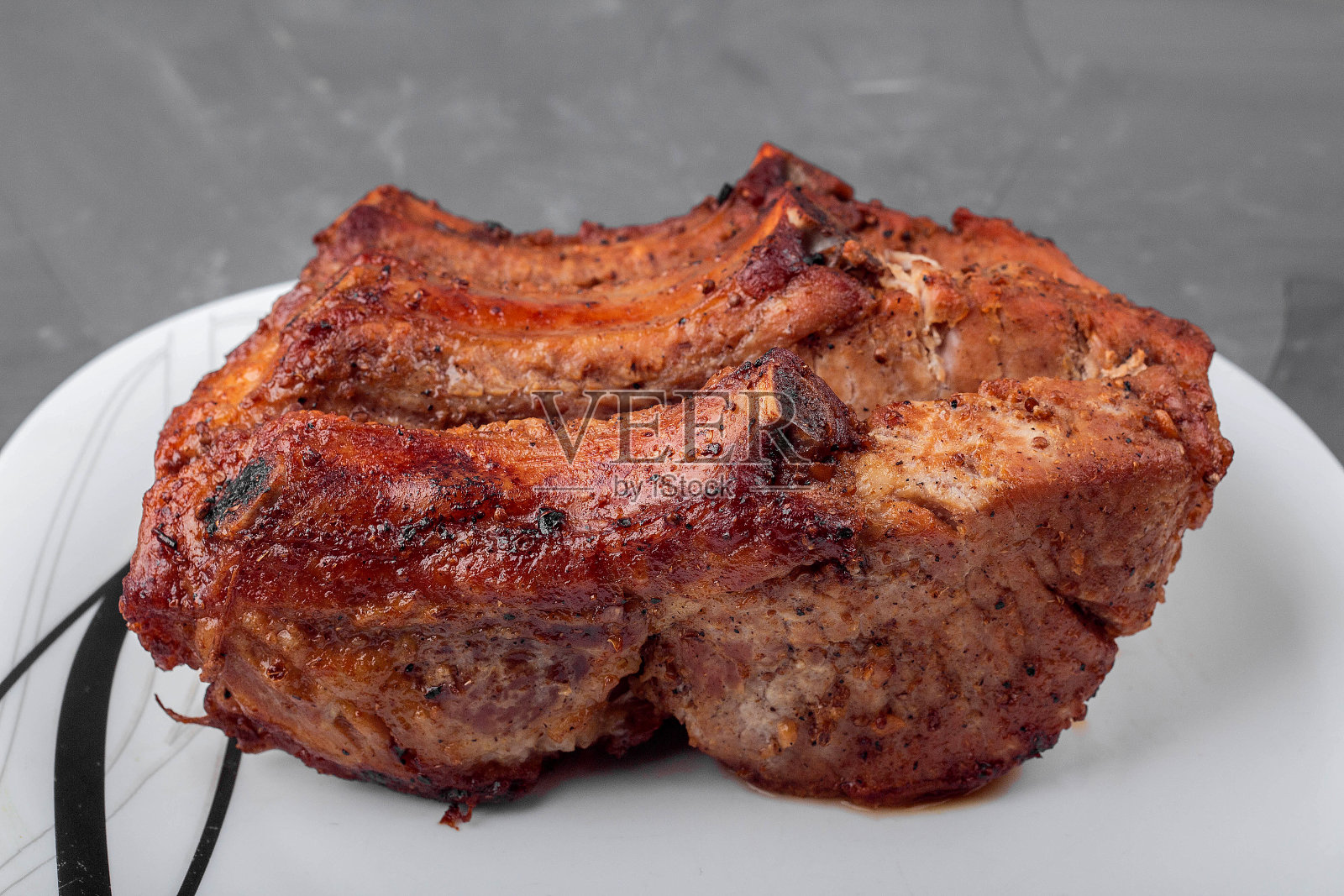 烤猪里脊放在白盘子里照片摄影图片