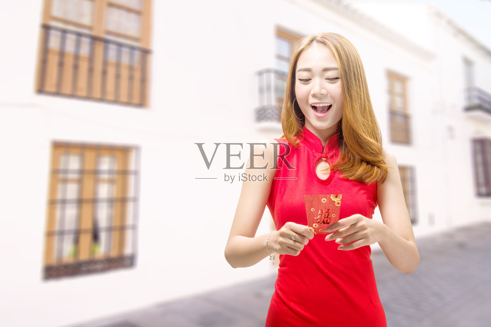 穿着旗袍拿着红包的亚洲华人妇女照片摄影图片