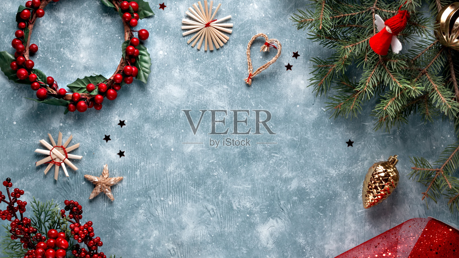 木制装饰品,红色的装饰品,金色的装饰物,蓝色木质背景上的松枝,复制空间。平铺,圣诞或新年相框。色调图像,俯视图照片摄影图片