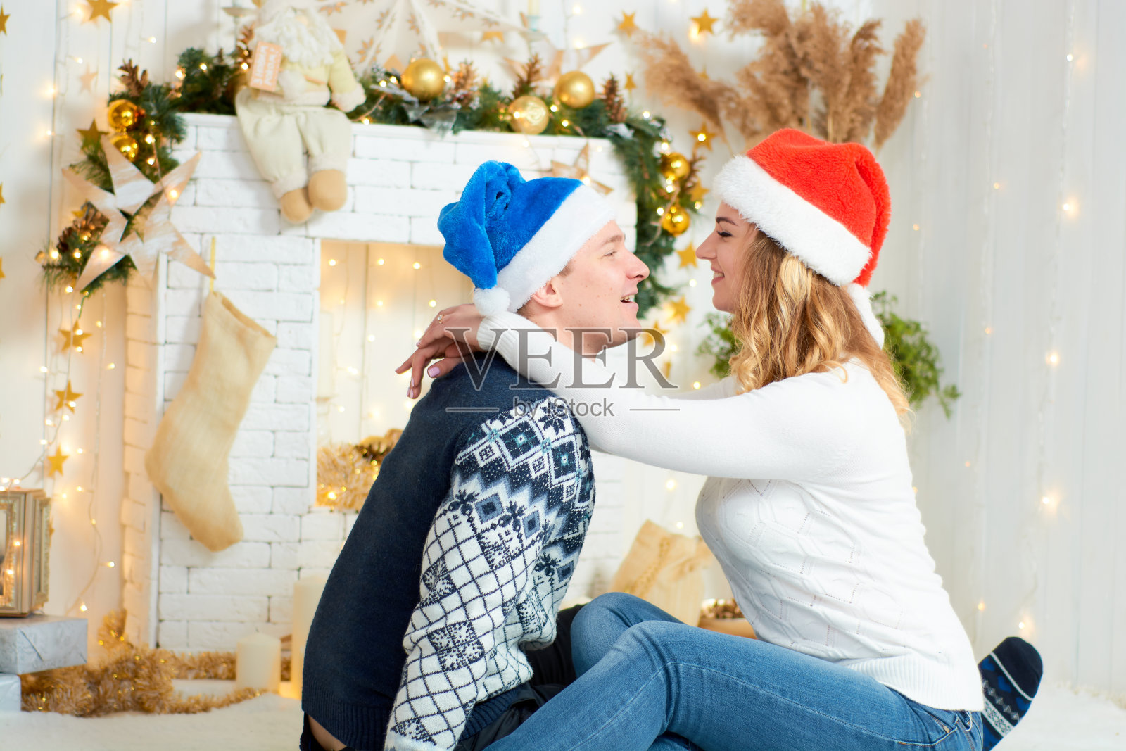 在圣诞背景下玩耍的年轻情侣照片摄影图片