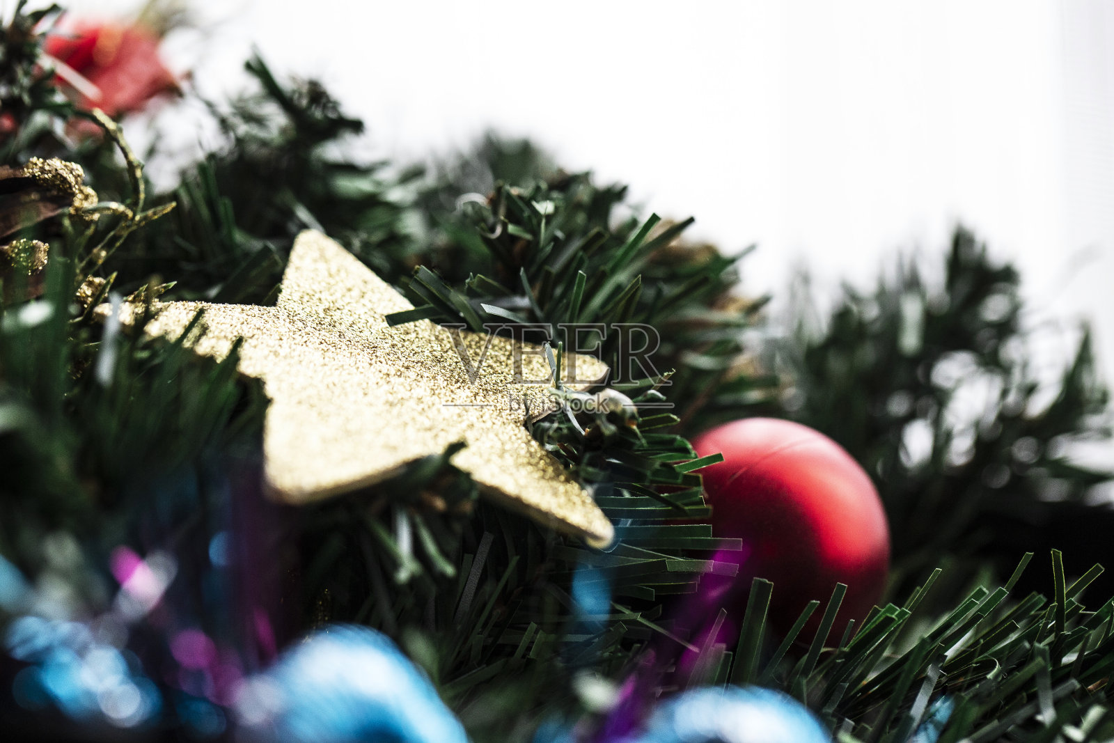 冷杉树叶上的圣诞装饰物白色背景,特克斯空间,圣诞树上的一颗金星和其他装饰物照片摄影图片