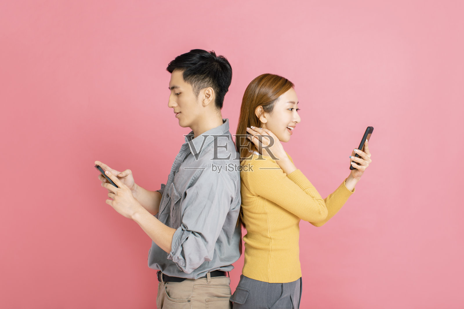 欢快的年轻夫妇站在那里看着智能手机照片摄影图片