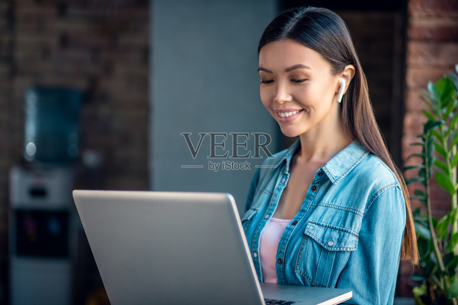 快乐的积极女人戴着她的无线耳机照片摄影图片