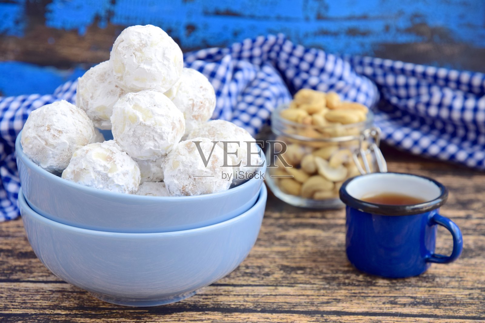 传统的圣诞腰果雪球饼干饼干上面覆盖糖霜粉。配上茶照片摄影图片
