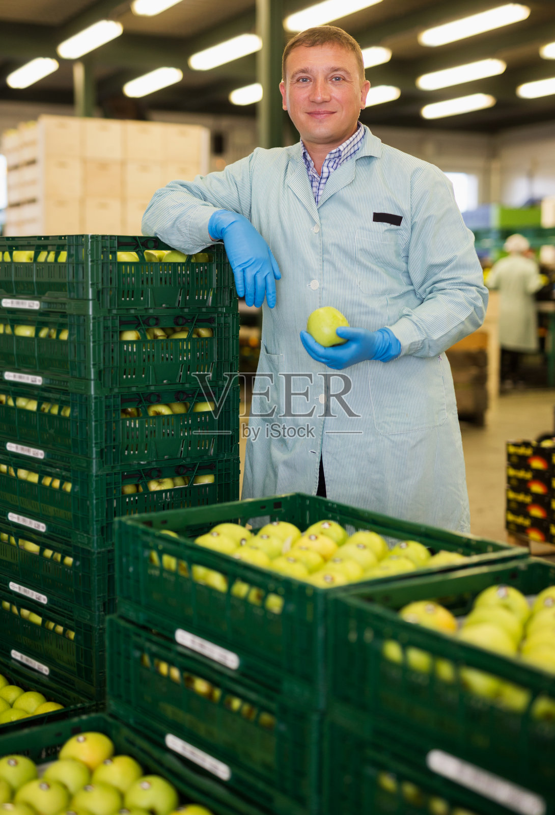 业主站在装满苹果的箱子旁照片摄影图片