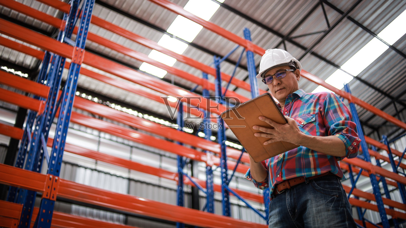 戴安全帽和蓝图的亚洲工程师在工厂工作照片摄影图片