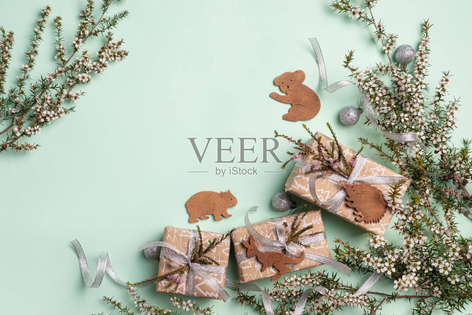 澳大利亚的圣诞节,用当地的茶树叶子,礼物和装饰在绿色的背景。照片摄影图片