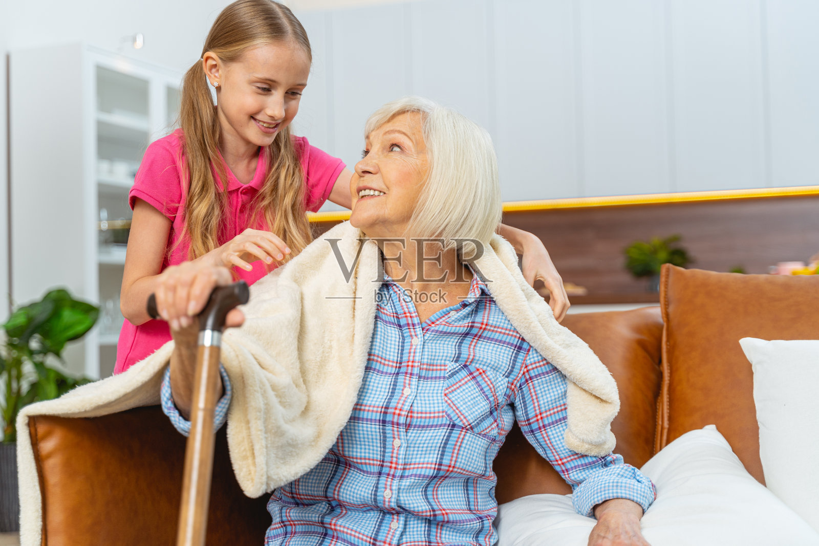 拄着拐杖的女人对着一个小女孩微笑照片摄影图片