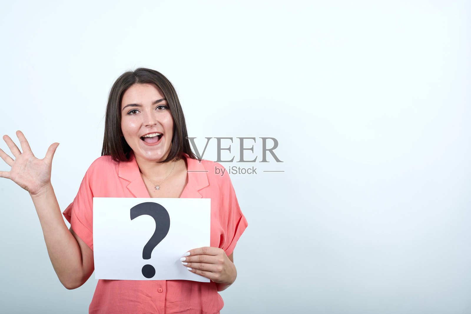 穿粉红色衬衫的迷人女人总是拿着带问号的纸发牢骚照片摄影图片