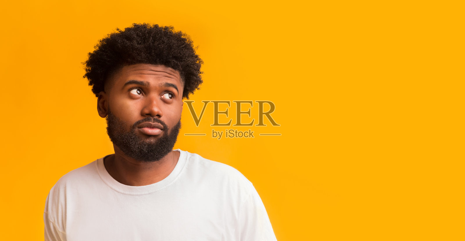 面露疑惑的年轻男子看着空白处照片摄影图片