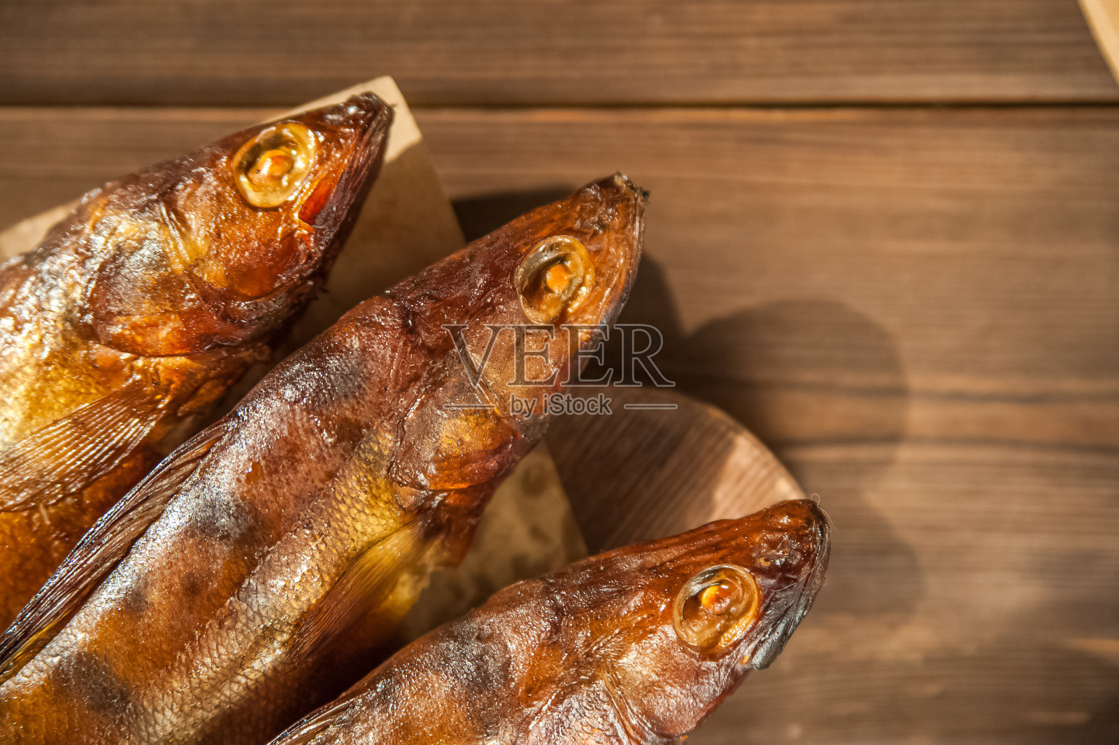 啤酒杯与啤酒和热熏鱼特写。啤酒杯,啤酒和鱼在黑暗的背景和复制空间。照片摄影图片