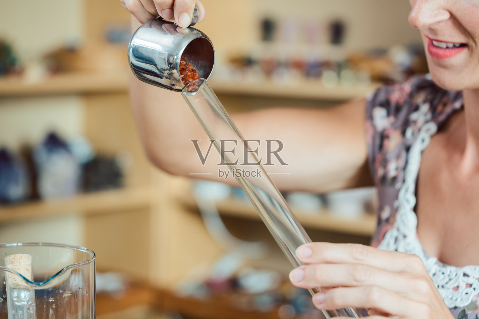 女人把红色宝石放进管子里照片摄影图片