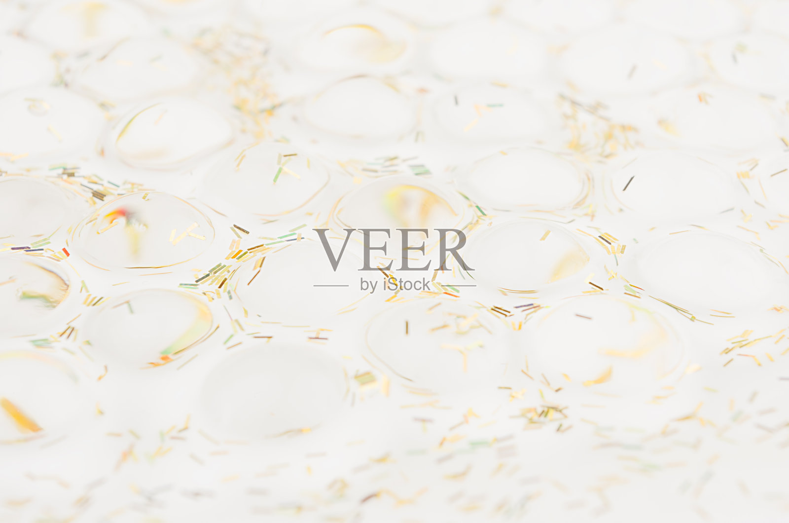 白色软光质感的堆透明球与金色闪光作为优雅的现代假日抽象背景。照片摄影图片