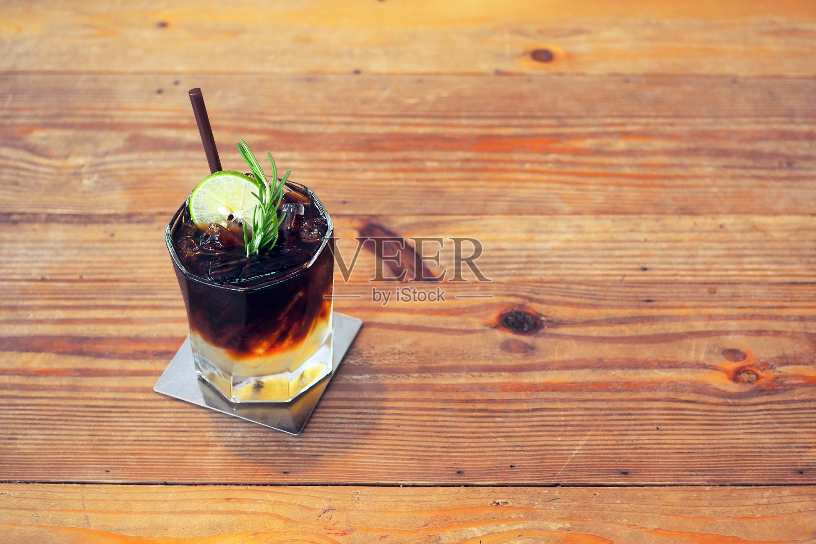 一杯冰美式咖啡,一层饰有百里香叶和柠檬片的橙汁和柠檬汁。照片摄影图片