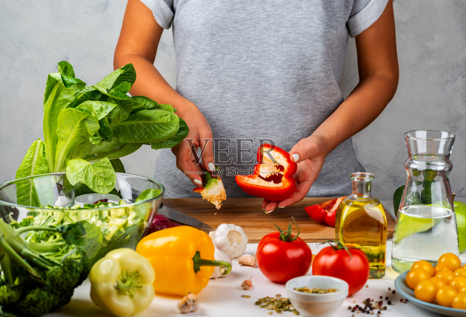 女人清洗辣椒,在厨房做沙拉。健康饮食的概念。照片摄影图片