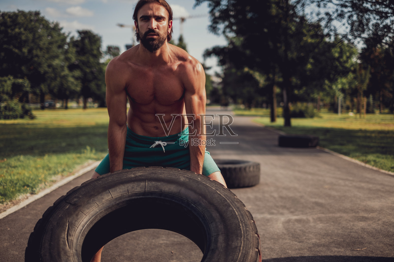 在公园里翻轮胎的壮汉照片摄影图片