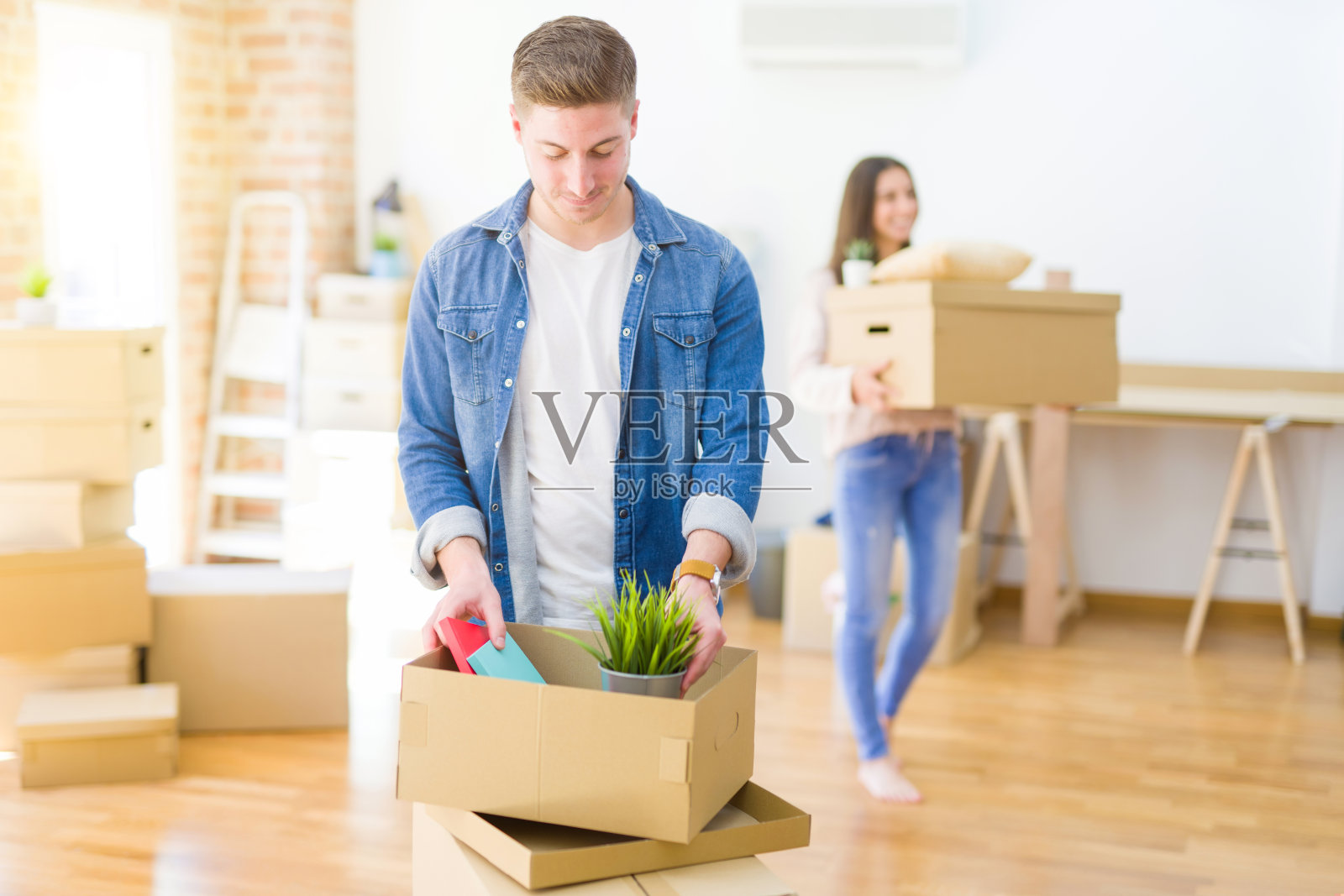 一对美丽的年轻夫妇搬到新家,对新公寓感到兴奋照片摄影图片