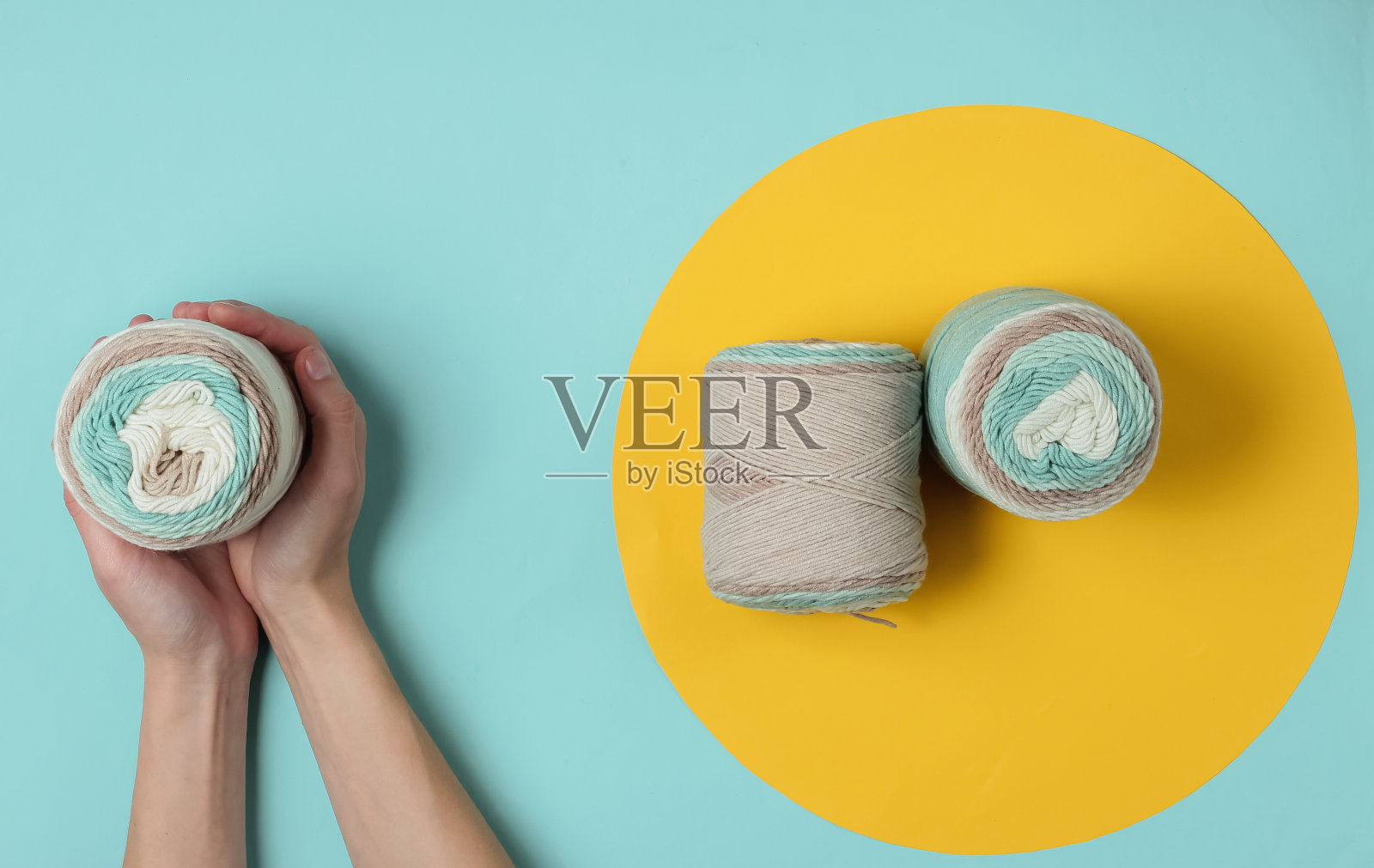 手拿着一束带圈的蓝色背景羊毛线。前视图。爱好。极简主义照片摄影图片