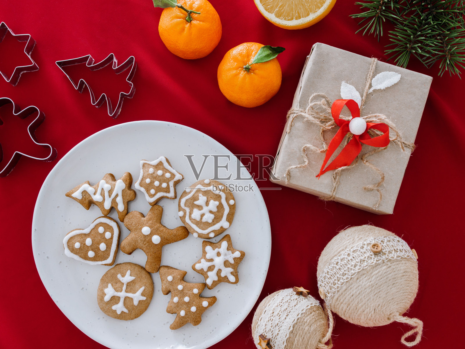 自制的星星形饼干放在盘子里,手拉手。圣诞静物与礼品盒和姜饼饼干,俯视图,圣诞背景与桔子。组成礼物,圣诞树上的装饰品和树枝,还有姜饼人照片摄影图片
