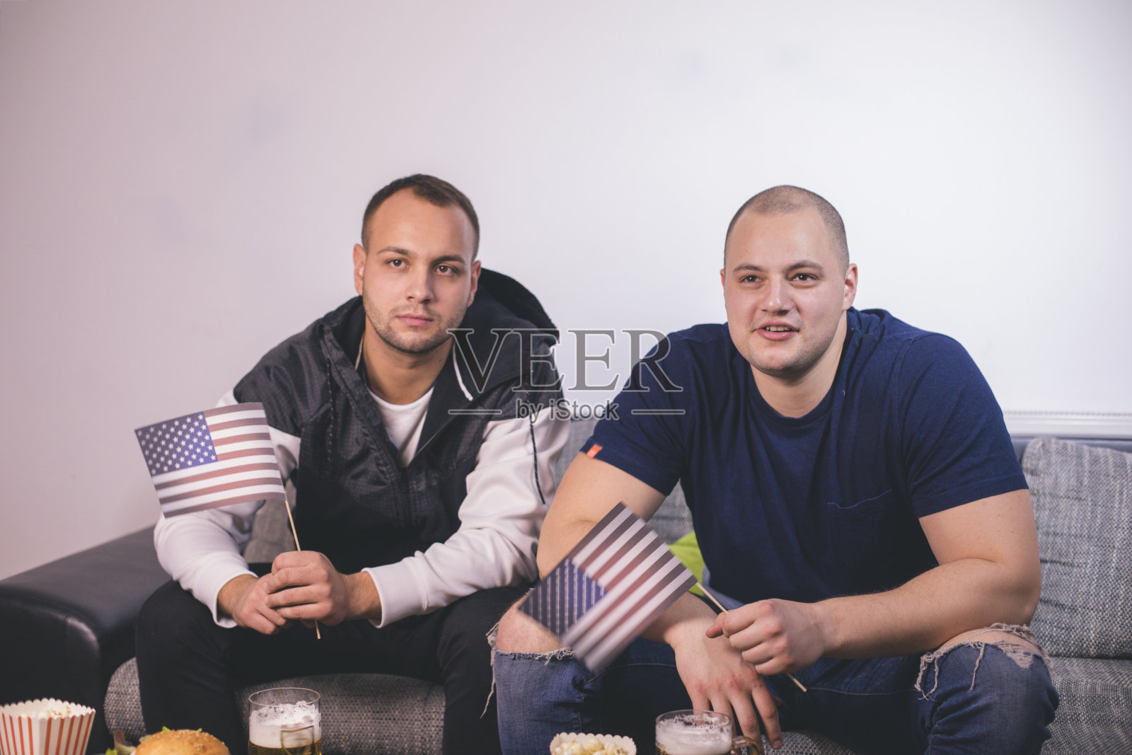 朋友们在电视上看体育节目照片摄影图片