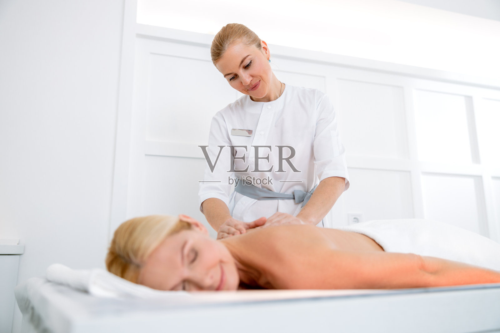 正在接受治疗和按摩治疗的快乐女人照片摄影图片