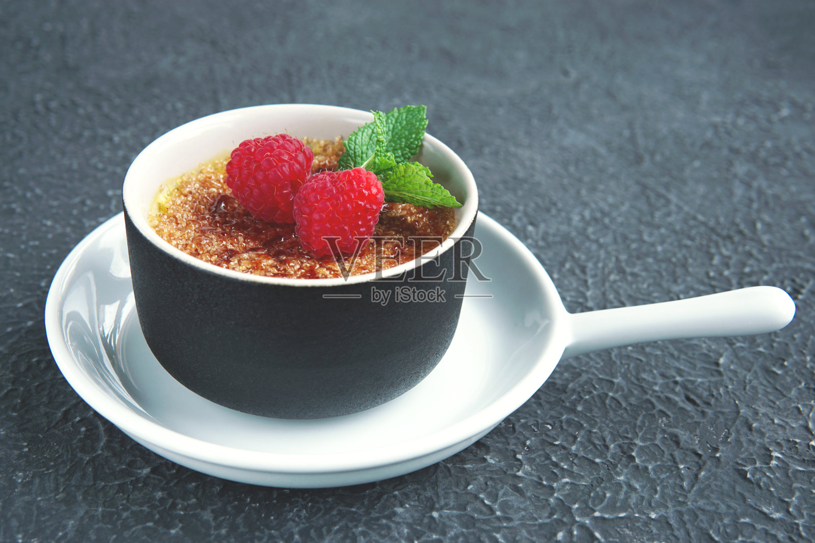 焦糖布丁或加覆盆子的加泰罗尼亚。传统的法国,西班牙和意大利香草奶油甜点与焦糖红糖。照片摄影图片