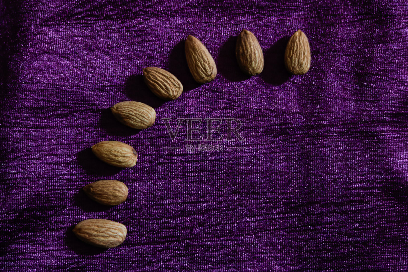 健康的杏仁在紫色的背景照片摄影图片