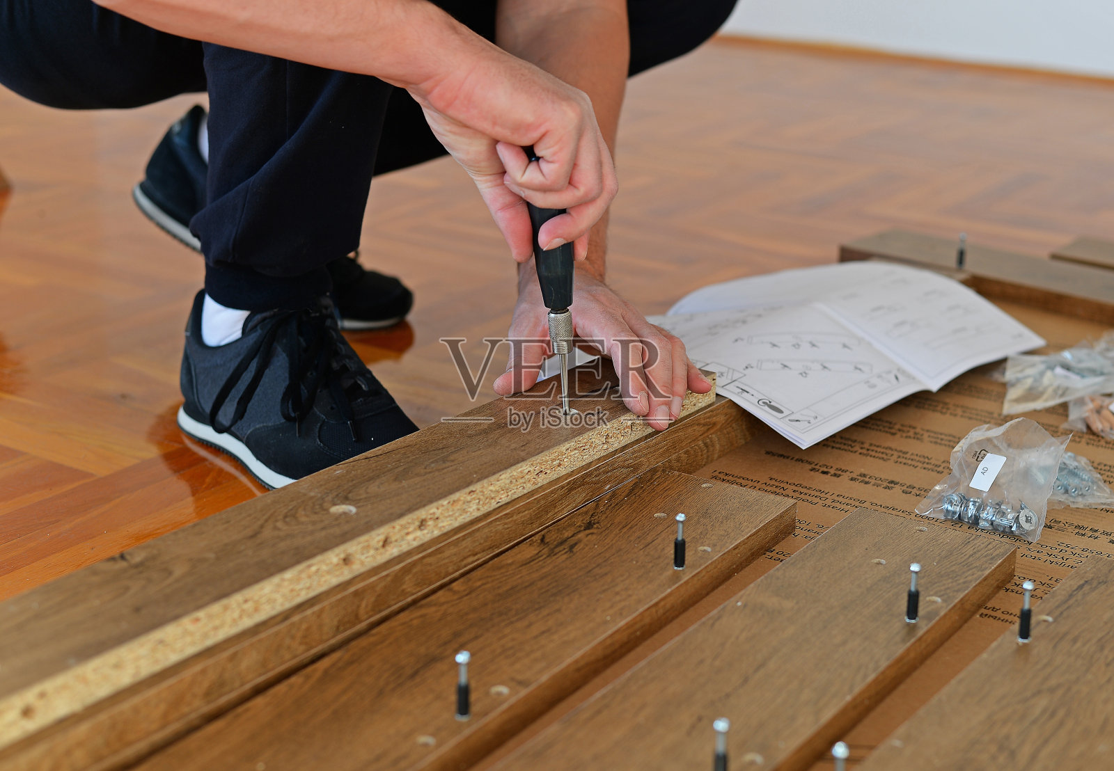 工人手里拿着一把螺丝刀,正在做木制家具照片摄影图片