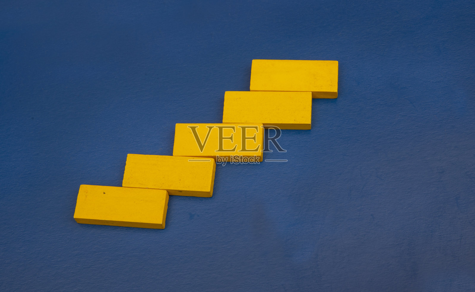 黄色木质立方体,蓝色背景,商业成功理念照片摄影图片