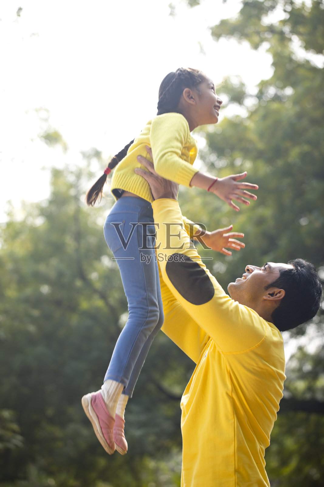快乐的父亲扶着女儿飞起来照片摄影图片