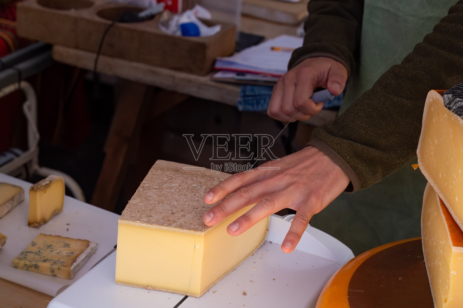 用钢丝钳切奶酪的小贩照片摄影图片
