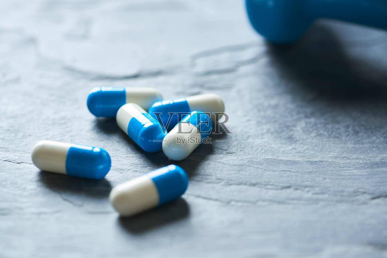 运动补充剂(肌酸胶囊)在黑暗的石头背景。关闭了。照片摄影图片