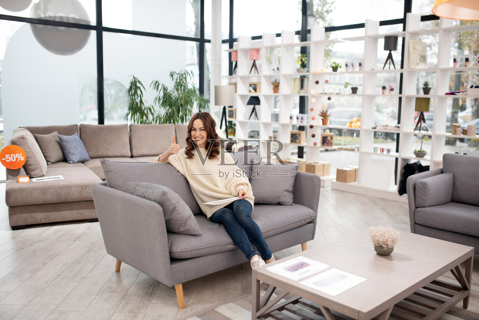 黑头发的女人穿着白衬衫和牛仔裤,看起来很满足照片摄影图片