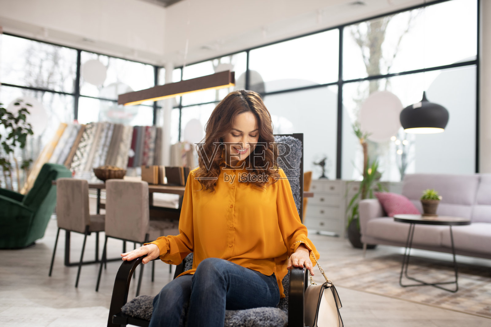 长发美女坐在舒适的扶手椅上照片摄影图片