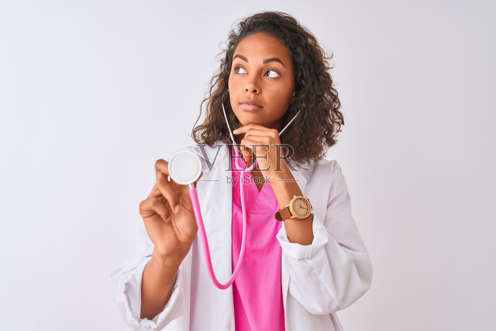 年轻的巴西女医生用听诊器站在孤立的白色背景严肃的脸上思考问题,很困惑的想法照片摄影图片