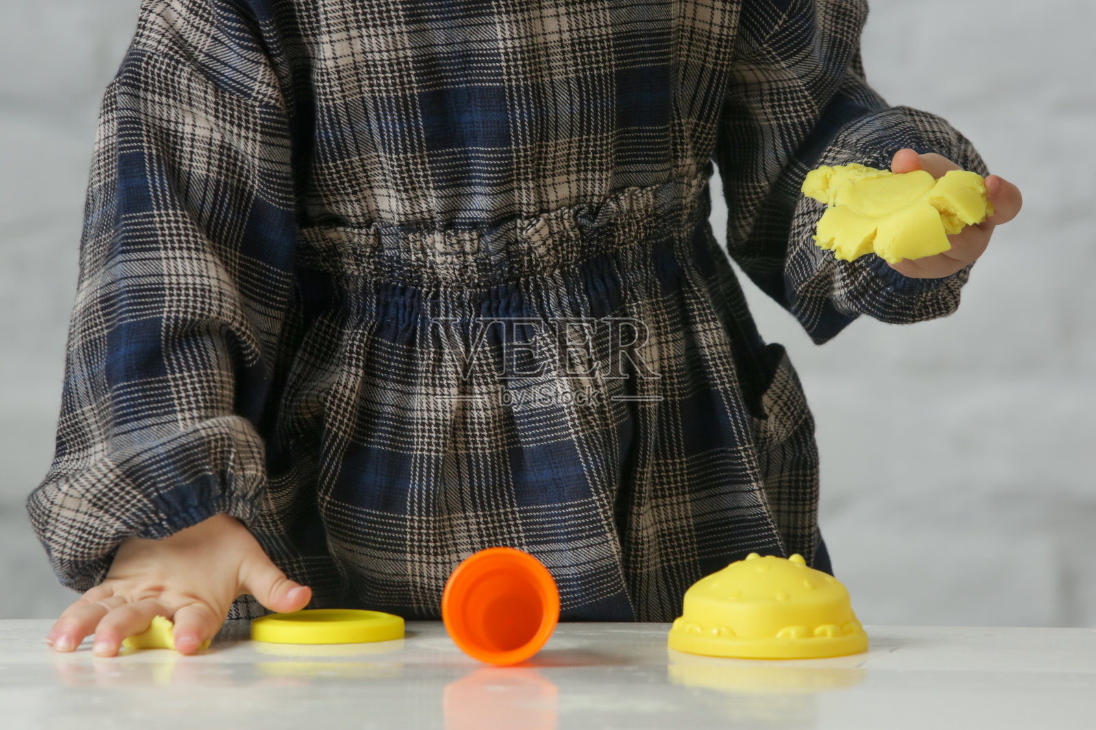 蹒跚学步的女孩玩粘土模型。Play dough可以让孩子们发展精细的运动技能,加强手指,手和手腕,并天生好奇,用他们的感官探索世界。照片摄影图片