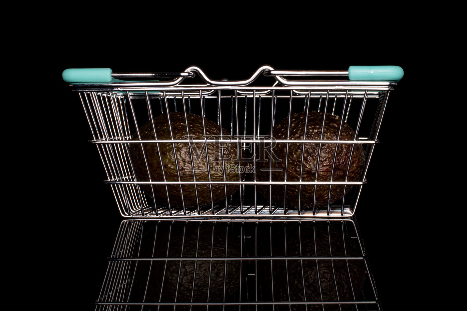 新鲜的绿色鳄梨孤立在黑色玻璃上照片摄影图片