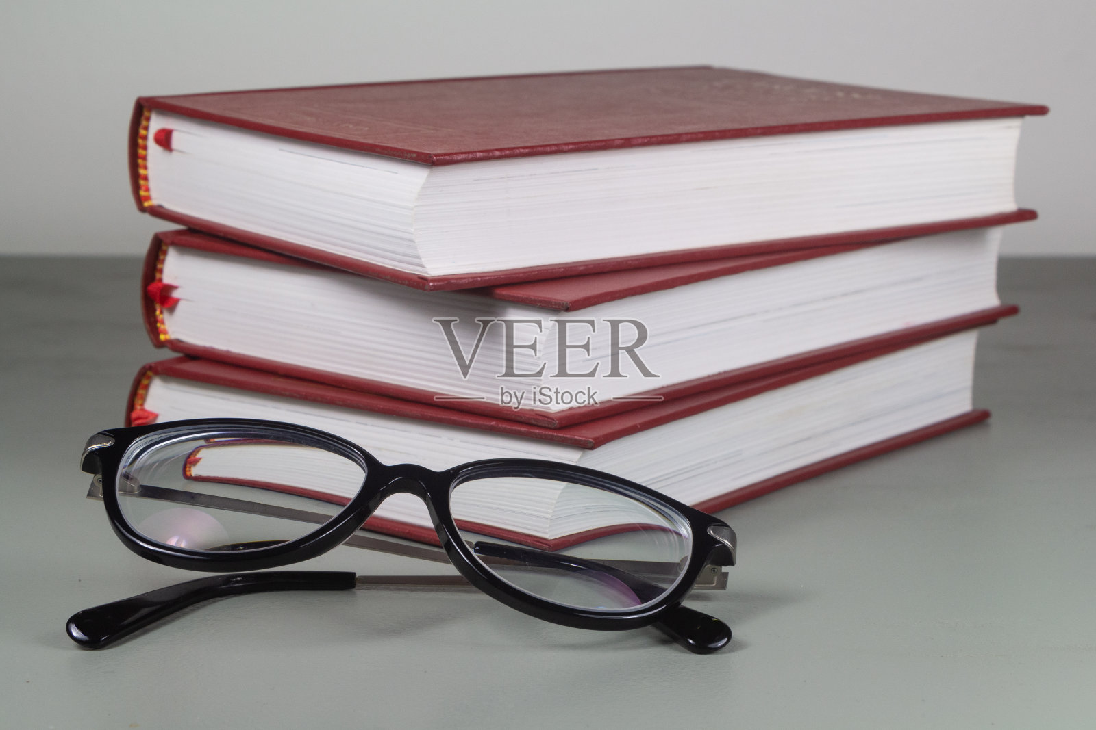 一堆红色的书和眼镜照片摄影图片