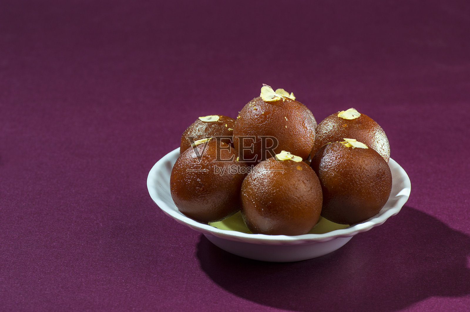 印度甜点:白碗里的古拉卜贾蒙照片摄影图片