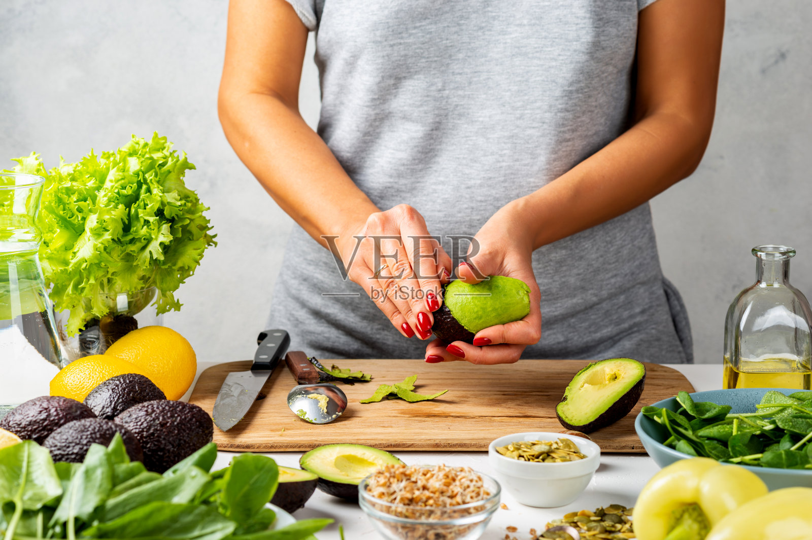 女人皮鳄梨。烹饪健康食品的理念。照片摄影图片