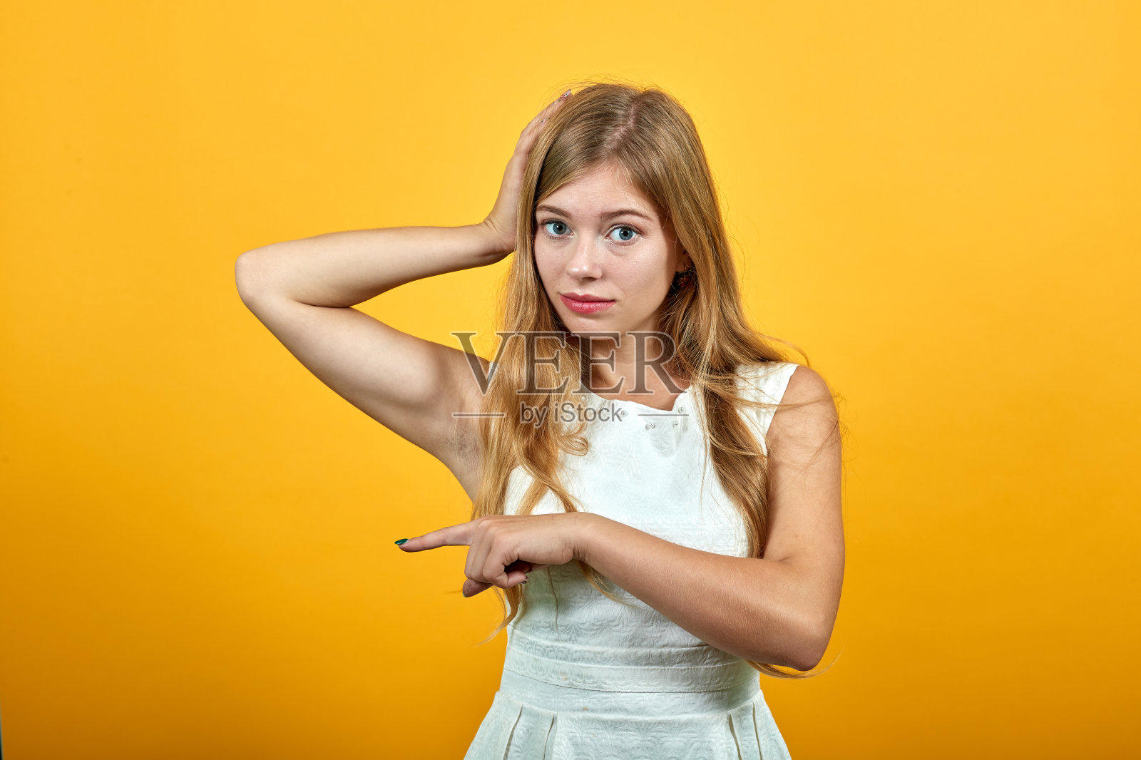 严肃的女人一只手放在头上,另一只手放在一边,看起来很悲伤照片摄影图片