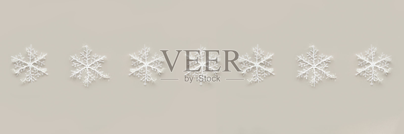 白色的雪花在灰色的背景上。照片摄影图片