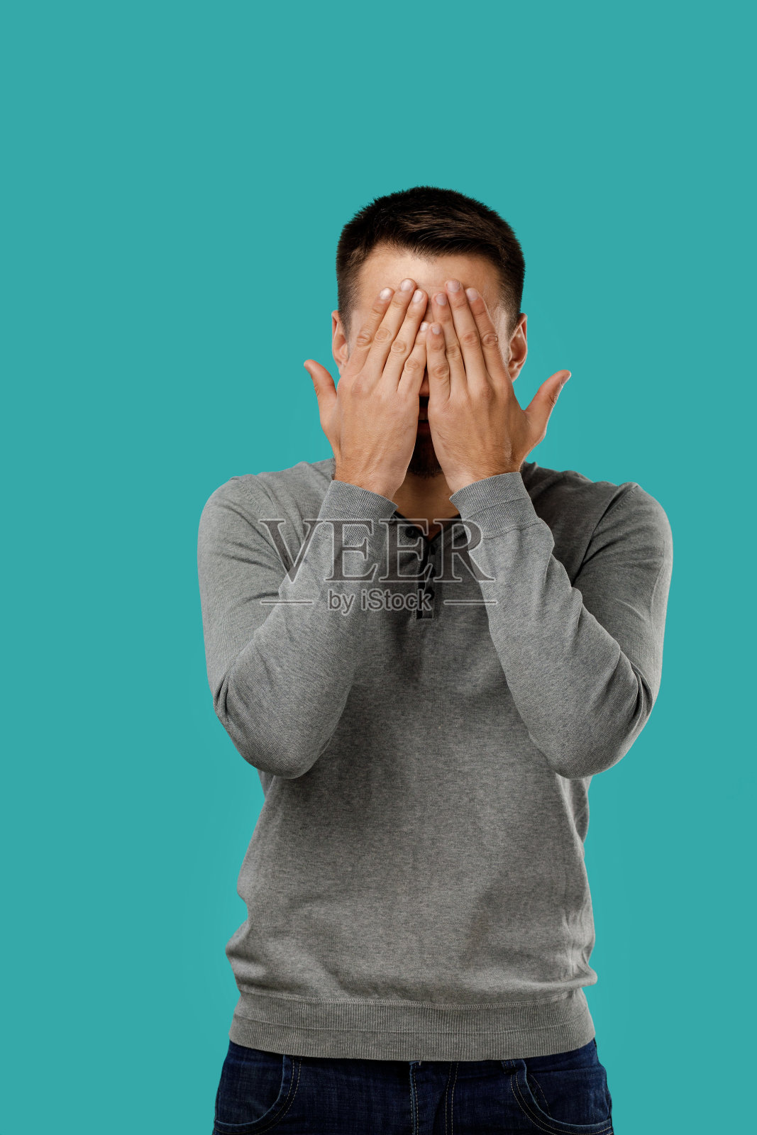 穿着灰色毛衣的大胡子男子用手闭上了眼睛照片摄影图片