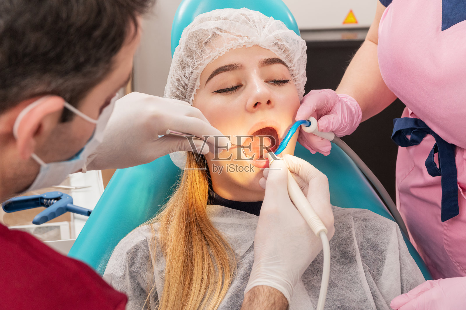 牙医用水给病人清洁牙齿照片摄影图片