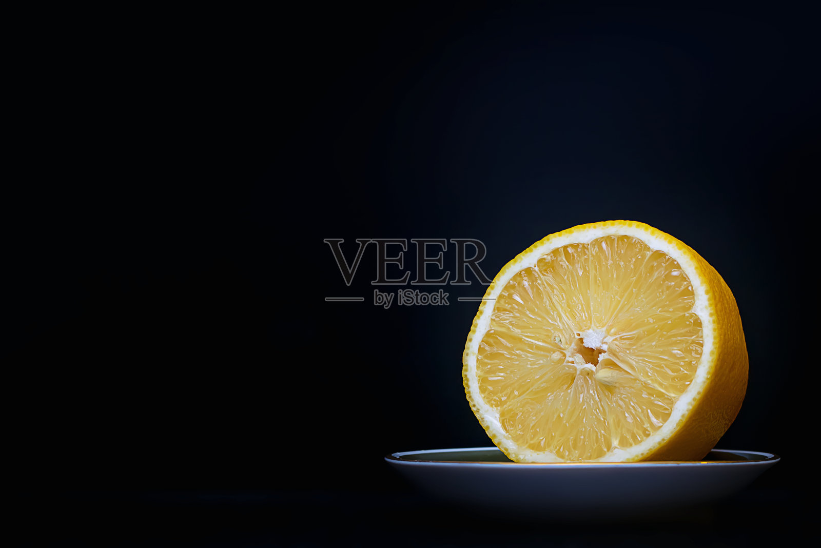 鲜切柠檬,黑色底碟照片摄影图片